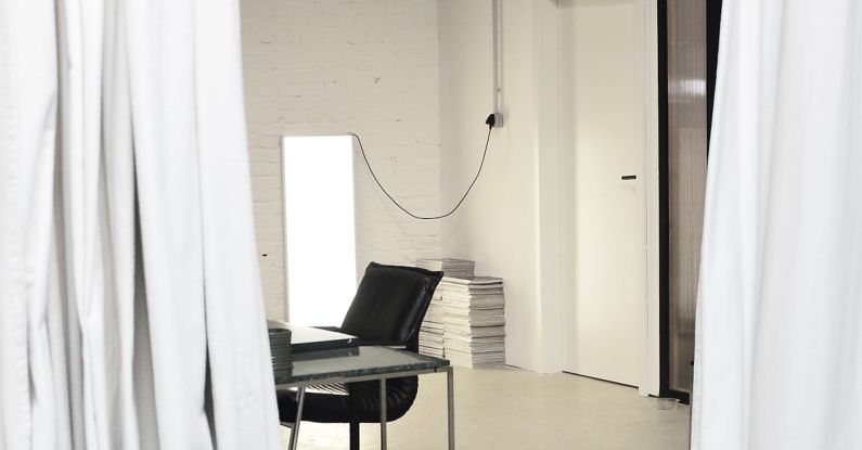 Professional Meeting - Interior of spacious loft studio with meeting table and chairs surrounded by hanging white curtains