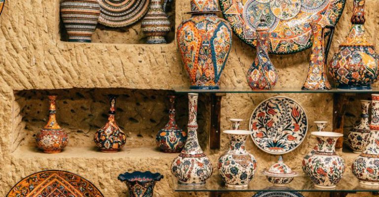 Cultural Differences - Collection of various decorative ceramic plates and vases placed on rough stone wall and floor