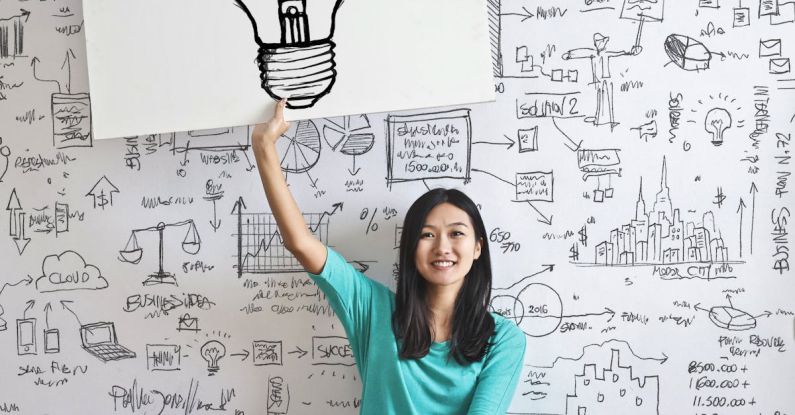 Brainstorming - Woman Draw a Light bulb in White Board