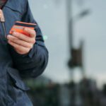 Customer Data - Male taking photo of credit card on smartphone on street in daytime
