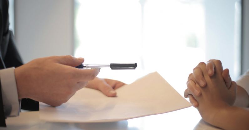 Business Credit - Crop businessman giving contract to woman to sign