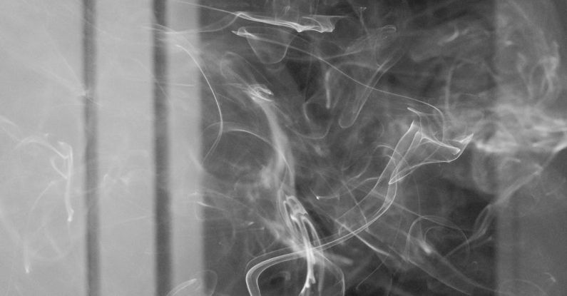 Habit Productivity - Cigarette smoke floating in dark room